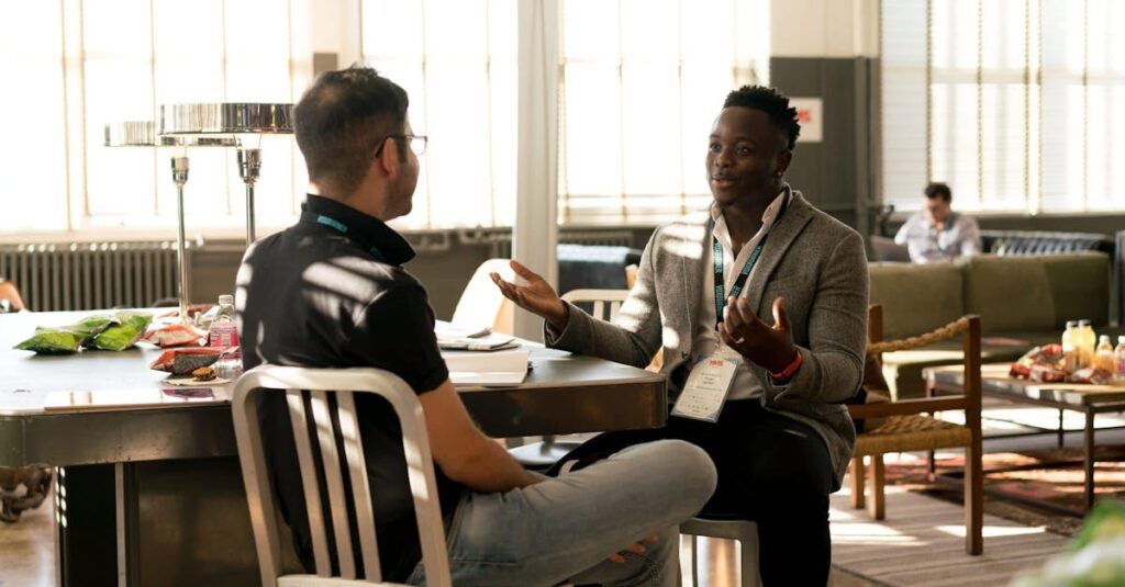 Two men having a casual discussion in a bright indoor setting, highlighting mentorship.